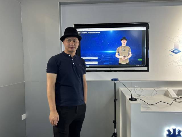 灵泽万川总经理和数字人“小何”。