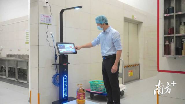 省实湛江学校食堂后厨内，工作人员正使用“学膳e管”平台配套电子秤进行食材智能入库。吴东俊 摄